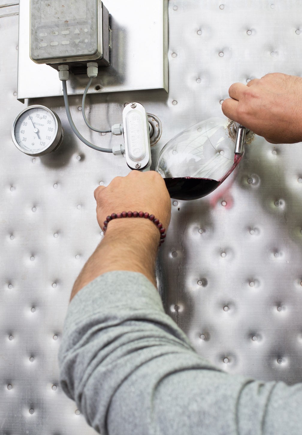 wine being drawn from stainless tank